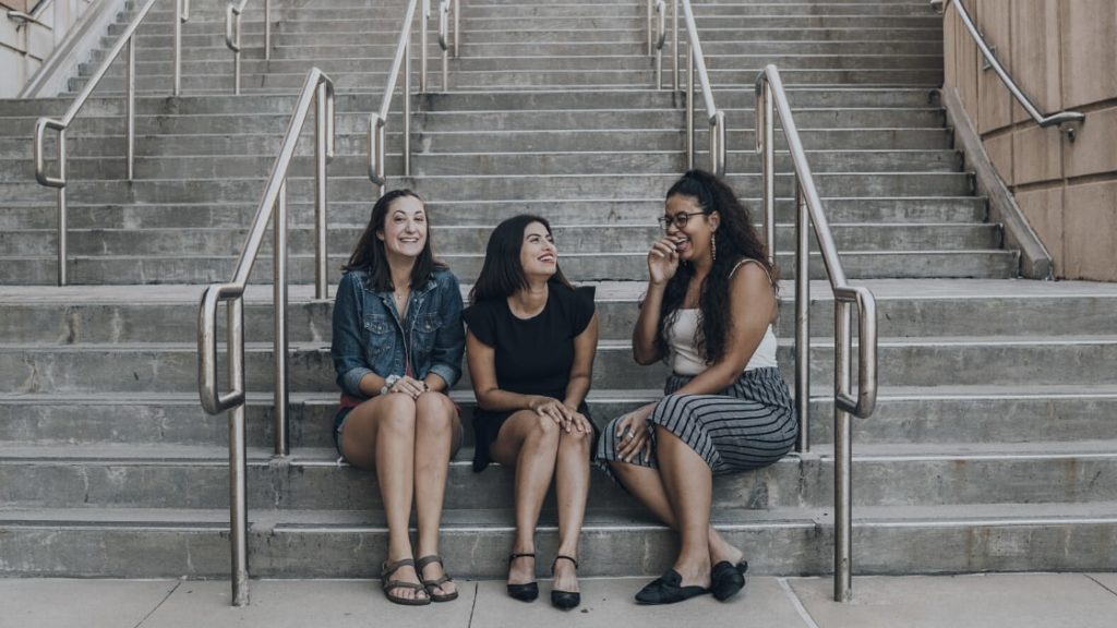 three women chatting on stairs