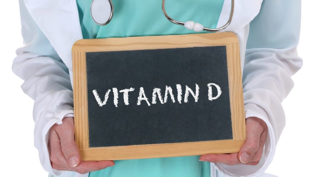 Doctor holding Vitamin D and Coronavirus sign