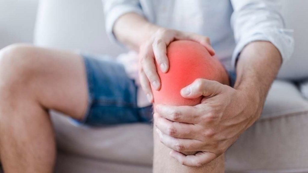 man grabbing his knee in pain with petellofemoral pain syndrome