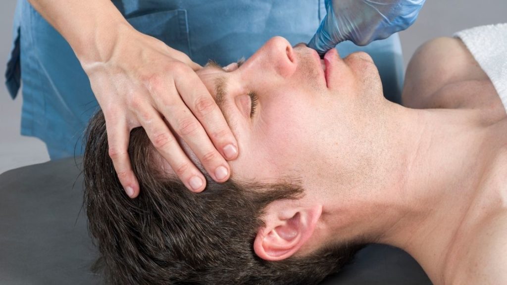 man getting intraoral massage in mouth
