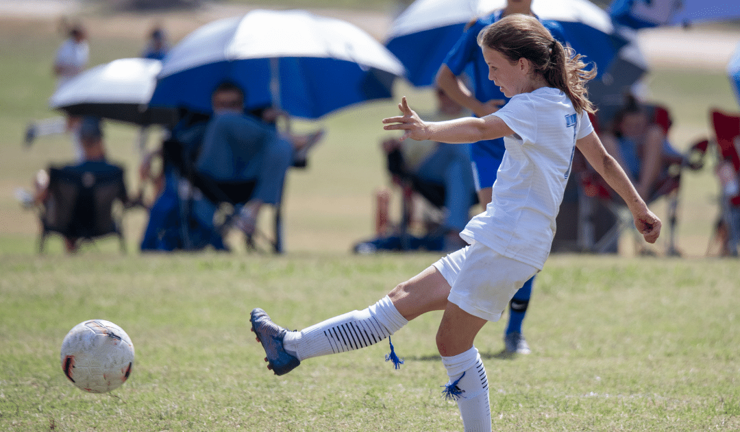 girl kicking a soccer ball
