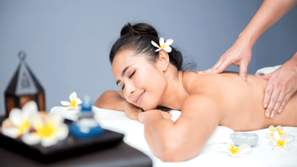 girl smiling and covered in flowers as she gets a back massage