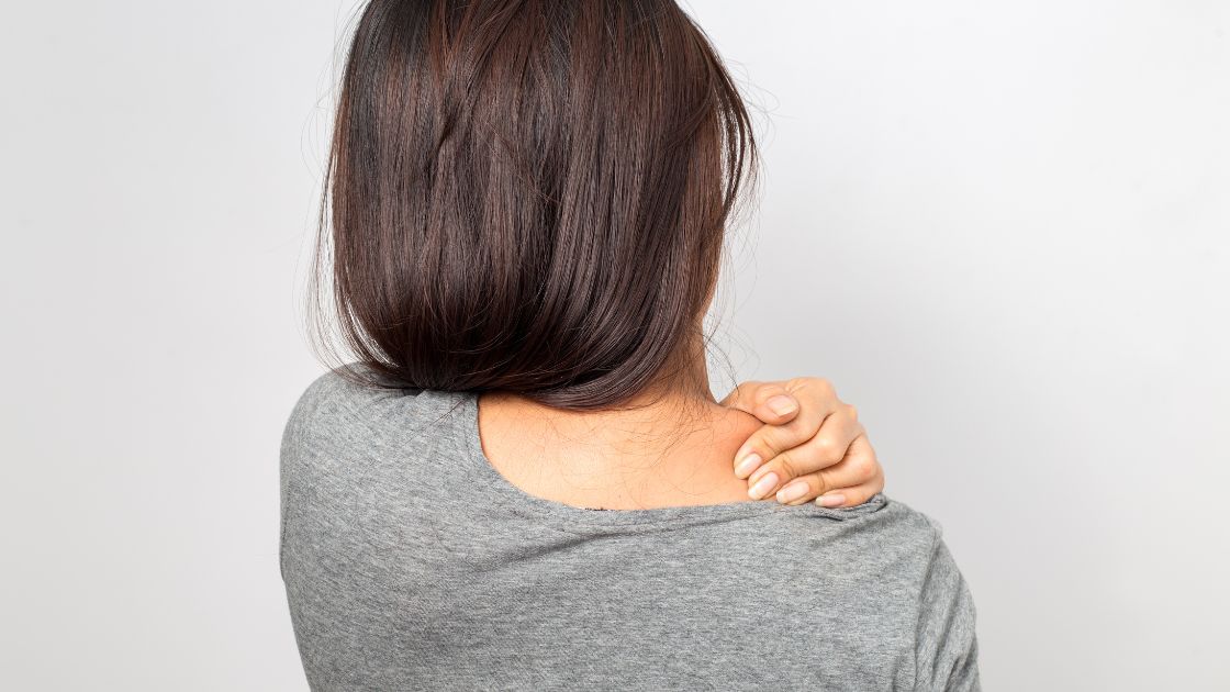 woman grabbing her shoulder in pain