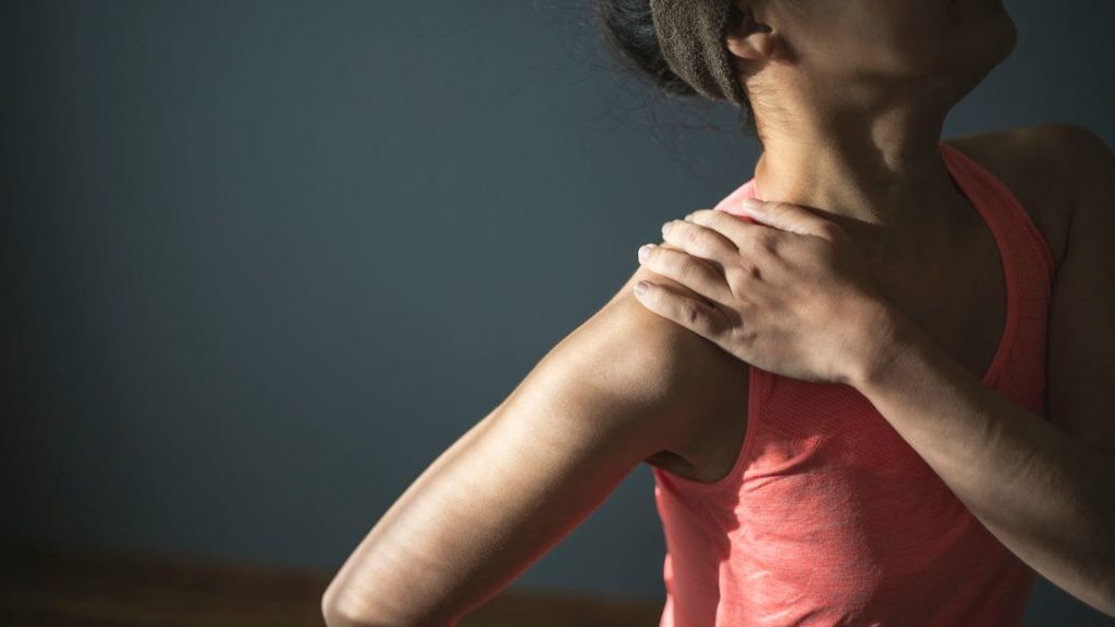 woman grabbing shoulder in pain with thoracic outlet syndrome