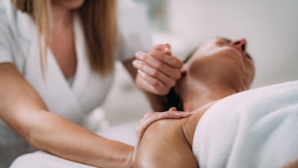 person receiving a neck massage from a massage therapist