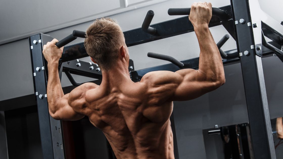 man with very strong back muscles doing chin ups
