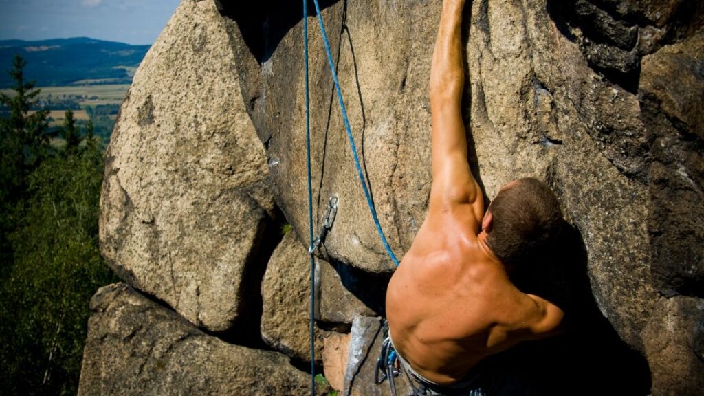 man rock climbing shirtless