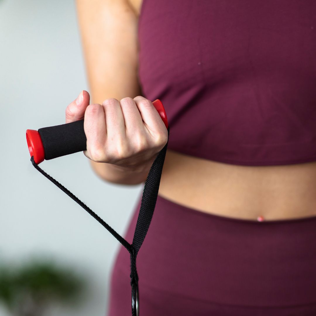 woman in burgandy doing wrist flexion with resistance band