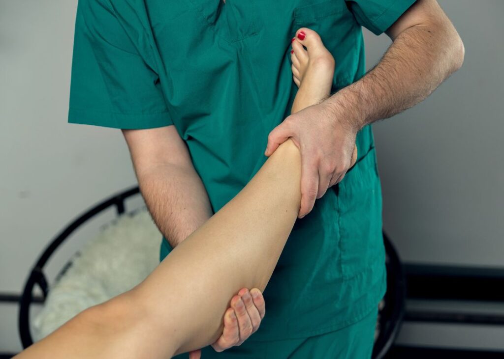 massage therapist performing a lymphatic drainage massage on patients foot and calf muscle
