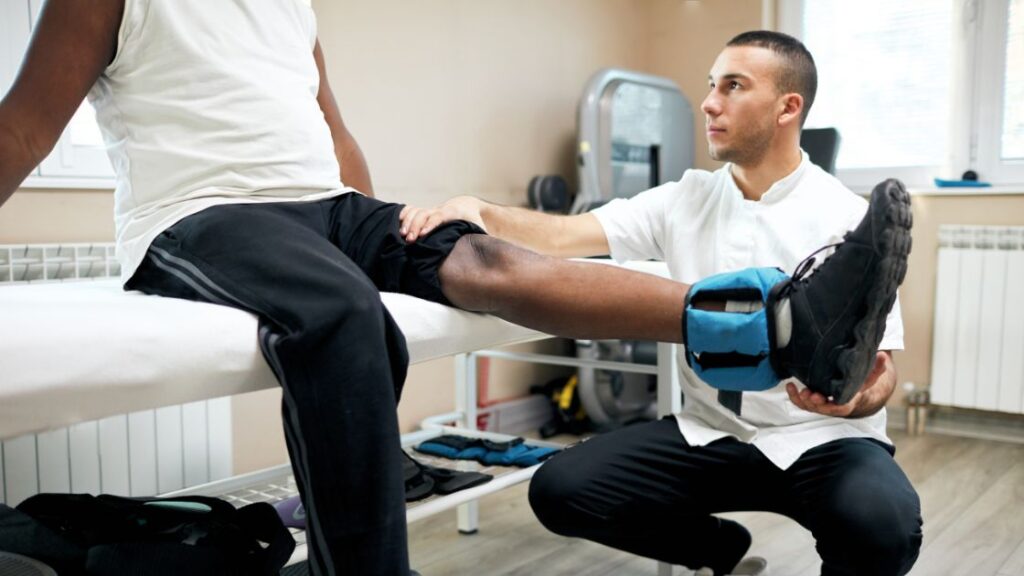 man with leg injury doing physical therapy with chiropractor