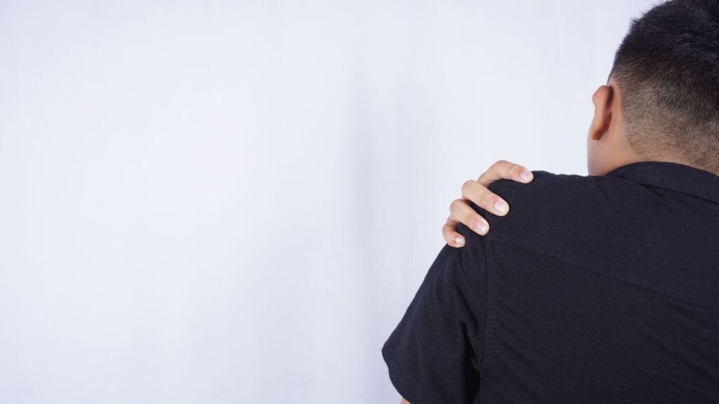 man grabbing shoulder with muscle pain