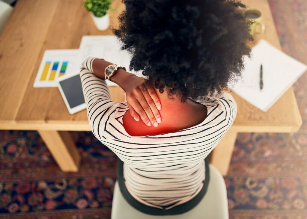 woman at desk with neck pain highlighted in red