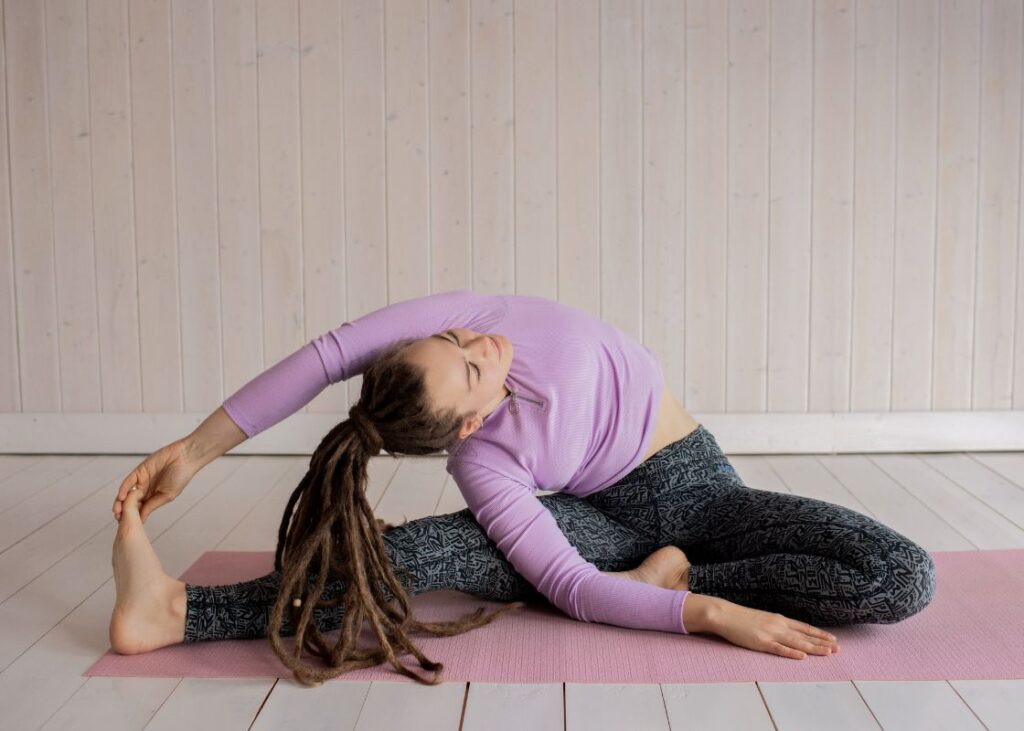 woman doing a yoga pose on the floor in a straddle