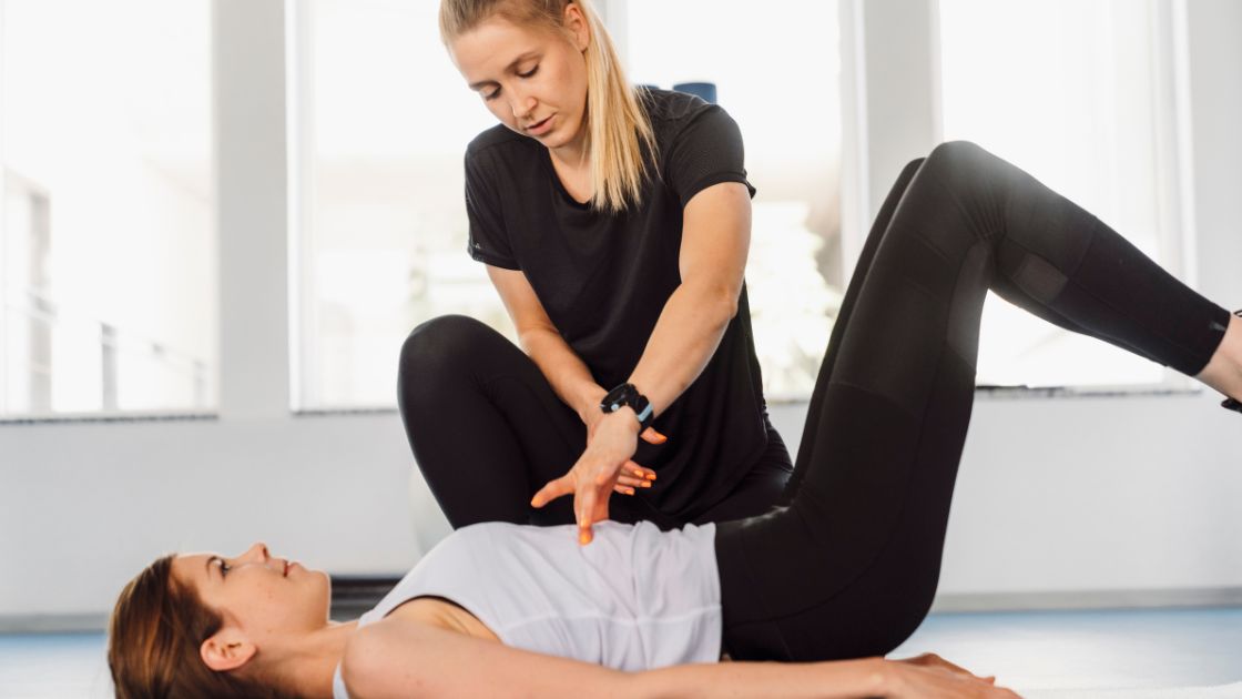 personal trainer helping client work on abs