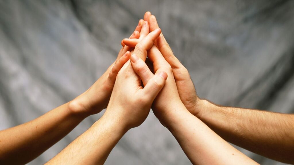 BH – What Makes Our 4-Step Pain Relief Protocol Different four hands high-fiving together in front of a grey background